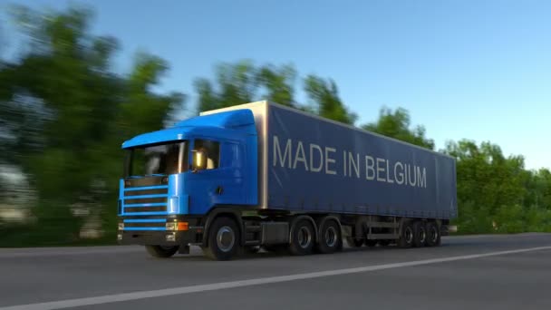 Fortkörning frakt semi truck med gjort i Belgien bildtext på släpet. Road cargo transport. Sömlös loop 4k klipp — Stockvideo