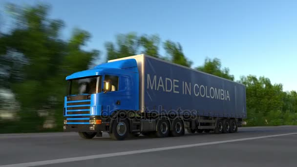 Snelheidsovertredingen vracht semi vrachtwagen met gemaakt In Colombia bijschrift op de aanhangwagen. Lading wegvervoer. Naadloze loops 4k clip — Stockvideo