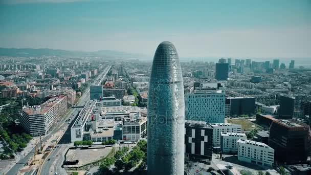 BARCELONA, ESPAÑA - 15 DE ABRIL DE 2017. Famoso rascacielos Torre Agbar. Vista aérea de la ciudad y el mar en un día soleado. 4K estableciendo tiro — Vídeo de stock