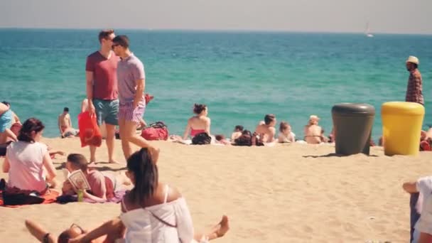 BARCELONA, ESPAÑA - 15 DE ABRIL DE 2017. Largo golpe steadicam de la gente tomando el sol en la playa de arena. Vídeo 4K — Vídeos de Stock