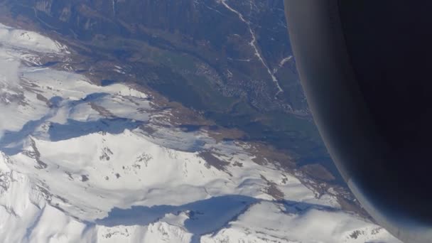 Motor de reacción de funcionamiento del avión, picos nevados del montain y ciudad alpina distante. Vídeo 4K — Vídeos de Stock