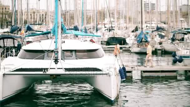 Barcelona, Spanyolország - április, 15, 2017. Kötik ki vitorlás katamarán és a vitorlások a marina rakpartok. 4k videóinak — Stock videók