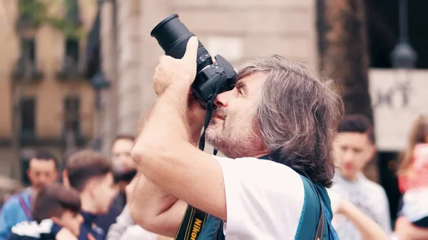 BARCELONA, ESPANHA - 16 de abril de 2017. Fotógrafo masculino maduro fazendo fotos ao ar livre com sua câmera Nikon DSLR — Fotografia de Stock