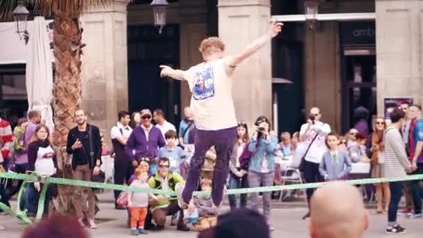 BARCELONA, ESPAÑA - 16 DE ABRIL DE 2017. Tightrope acrobat actuando en la calle. Equilibrio en una correa oscilante. Vídeo 4K — Vídeos de Stock