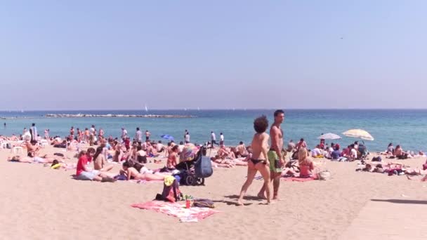 BARCELONA, ESPAÑA - 15 DE ABRIL DE 2017. Steadicam tiro de personas tomando el sol en la playa de arena. Vídeo 4K — Vídeo de stock