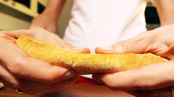 Nő torning egy darab friss francia kenyeret. Közeli kép: lassú mozgás, lövés — Stock videók