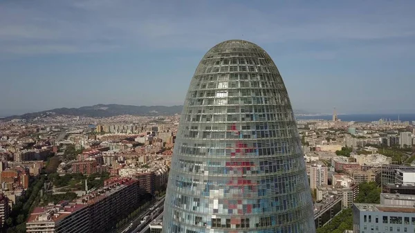 BARCELONA, ESPAÑA - 15 DE ABRIL DE 2017. Parte superior del famoso rascacielos Torre Agbar y paisaje urbano en un día soleado — Foto de Stock