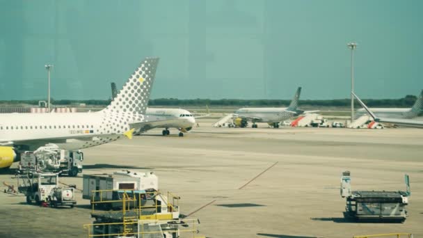 Barcelona, Spanje - April, 15, 2017. Pan shot van een commerciële vliegtuigen van Vueling Airlines taxiën en op de luchthaven El Prat wordt gehandhaafd. 4k video — Stockvideo