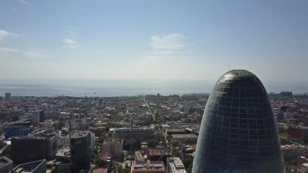 BARCELONA, ESPAÑA - 15 DE ABRIL DE 2017. Arriba de la torre Agbar y frente al mar en un día soleado. Vídeo aéreo 4K — Vídeo de stock