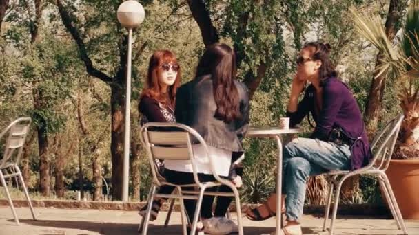 BARCELONA, ESPAÑA - 15 DE ABRIL DE 2017. Tres mujeres asiáticas jóvenes se sientan en la cafetería turística de la calle. Vídeo 4K — Vídeo de stock