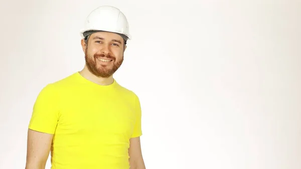 Retrato de ingeniero de construcción alegre guapo o arquitecto en camiseta amarilla y sombrero duro sobre fondo blanco — Foto de Stock