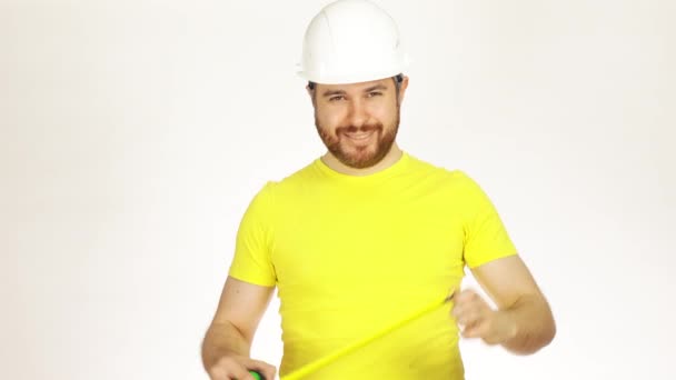 Inżynier budowy szczęśliwy lub architekt w żółty tshirt i kask za pomocą taśmy miara na białym tle. wideo 4k — Wideo stockowe