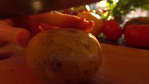Mladá žena řezání syrového bramboru na dřevěném prkénku. Vaření doma. 4k snímku — Stock video