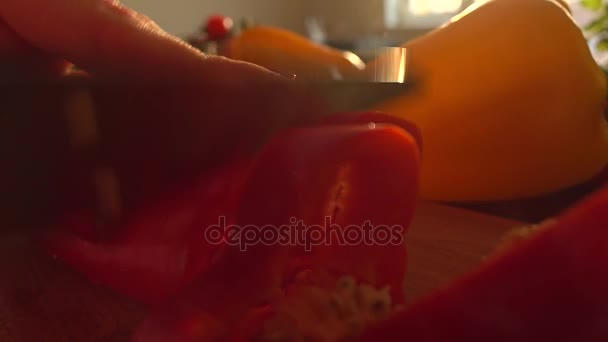 Cortando pimentão doce vermelho em uma tábua de madeira. Alimentação saudável e cozinhar em casa conceitos. 4K tiro — Vídeo de Stock