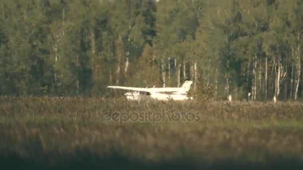 Telephoto lens pan shot of small propeller plane takeoff beyond grass and heat haze. 4K video — Stock Video