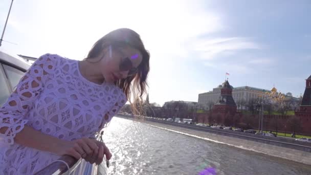 Hermosa mujer joven mirando el Kremlin de Moscú desde el barco de la gira del río. Vídeo en cámara lenta — Vídeos de Stock