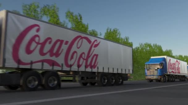 Semi-caminhões de carga com logotipo Coca-Cola dirigindo ao longo da estrada da floresta, loop sem costura. Editorial 4K clip — Vídeo de Stock
