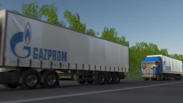 Semirimorchi merci con logo Gazprom che guidano lungo la strada forestale, anello senza soluzione di continuità. Editoriale clip 4K — Video Stock