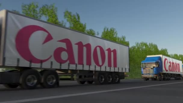 Semirimorchi merci con logo Canon Inc. che guidano lungo la strada forestale, anello senza soluzione di continuità. Editoriale clip 4K — Video Stock