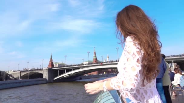 Kobieta w białej sukni, patrząc na Kreml z łodzią rzeki. Podróż do Rosji koncepcja. Film w zwolnionym tempie — Wideo stockowe