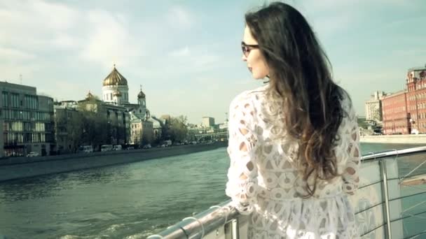 Femme brune en robe blanche regardant la cathédrale Christ Sauveur à Moscou. Clip à mouvement lent — Video