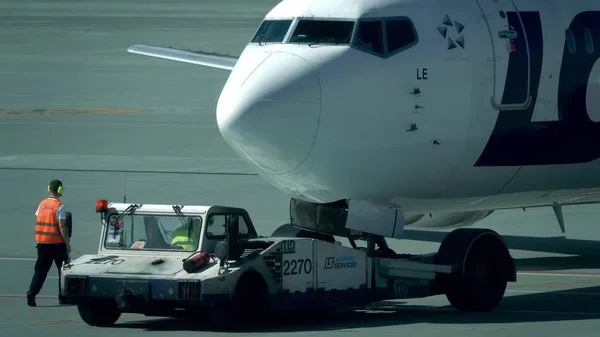 Varsó, Lengyelország - május, 18, 2017. Vontató kamion Airport kócok utasszállító repülőgép. Teleobjektív lövés — Stock Fotó