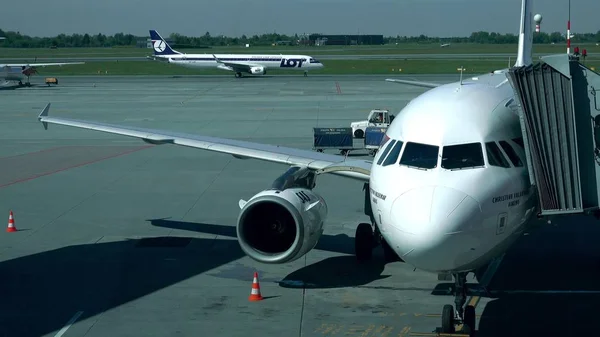 ADVERTÊNCIA, POLÓNIA - 18 DE MAIO DE 2017. SAS Airbus avião com ponte jato anexado e taxiing LOT avião no aeroporto de Chopin — Fotografia de Stock