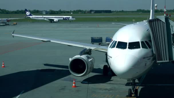 Warsaw, Polen - mei, 18, 2017. SAS Airbus passagiersvliegtuig met bijgevoegde jet brug en taxiën veel vliegtuig op de luchthaven van Chopin. 4k schot — Stockvideo