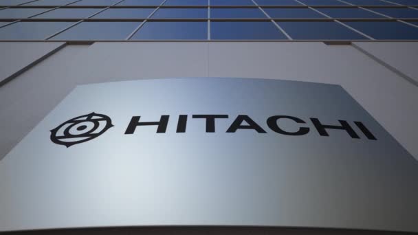 Tablero de señalización exterior con logotipo Hitachi. Moderno edificio de oficinas. Representación Editorial 3D — Vídeos de Stock