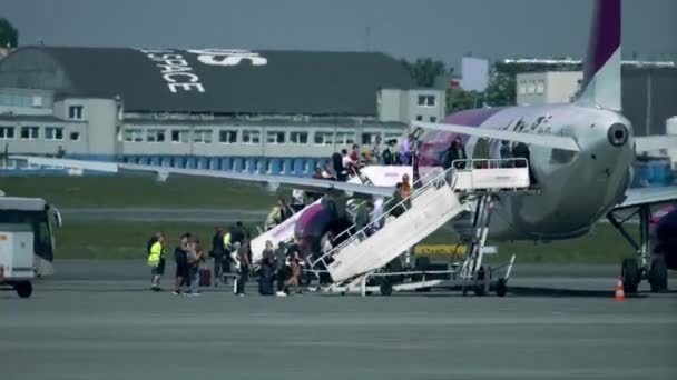 ADVERTÊNCIA, POLÓNIA - 18 DE MAIO DE 2017. Wizz Air Airbus A320-232 embarque de avião através de duas rampas no aeroporto. 4K teleobjectiva vídeo — Vídeo de Stock