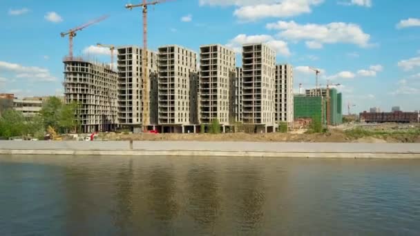 Antenn skott moderna flerbostadshus byggarbetsplatsen nära waterfront. 4k-video — Stockvideo