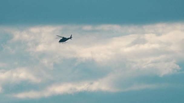 Helikopter vliegen snel tegen de bewolkte hemel. 4 k telelens pan schot — Stockvideo