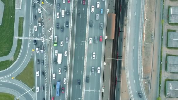 Aerial stigande uppifrån Visa skott av trafikstockning på en motorväg och glidande tåg i rusningstid. 4 k klipp — Stockvideo