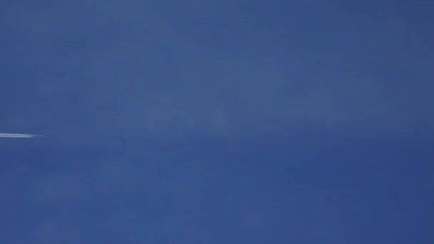 青い空に contrain を残しての民間航空機を飛行します。4 k 望遠レンズ ビデオ — ストック動画