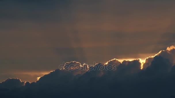 Los rayos del sol poniente por encima de las nubes ondulantes en la noche. 4K lapso de tiempo — Vídeo de stock