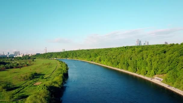 Tiro aéreo do rio de Moscou, aterro de parque de Fili e arranha-céus distantes em um dia ensolarado. Clipe 4K — Vídeo de Stock