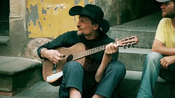 WARSAW, POLAND - ИЮНЬ 10, 2017. Веселый зрелый уличный музыкант, играющий на гитаре и поющий — стоковое видео