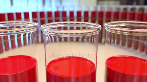 Кільце скляних флаконів з кров'ю або червоною рідиною. Концепція хімічної або медичної лабораторії. 4K безшовна петля затискача — стокове відео