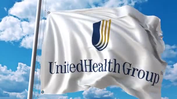 Acenando bandeira com o logotipo do Grupo Unitedhealth contra nuvens em movimento. Animação editorial 4K — Vídeo de Stock