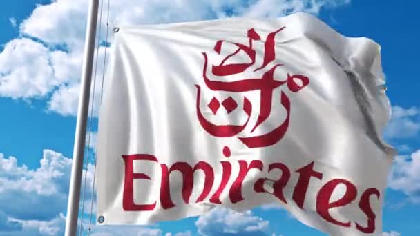 Drapeau arborant le logo Emirates Airlines contre les nuages mouvants. Animation éditoriale 4K — Video