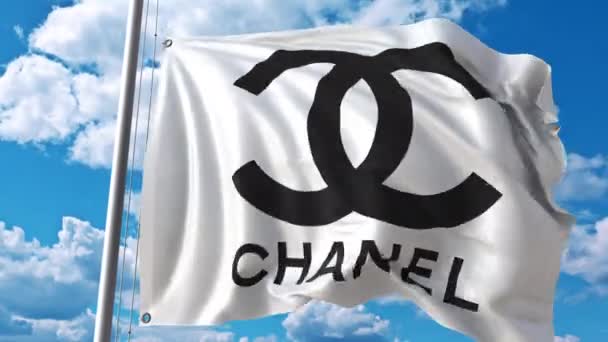 Mengayunkan bendera dengan logo Chanel melawan awan bergerak. Animasi editorial 4K — Stok Video