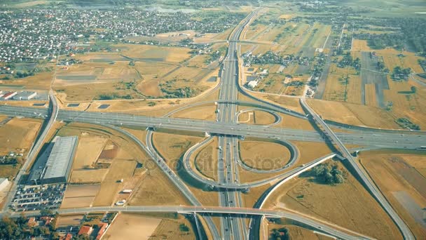 Tiro aéreo do intercâmbio de rodovias moderno nos arredores em um dia ensolarado de outono — Vídeo de Stock