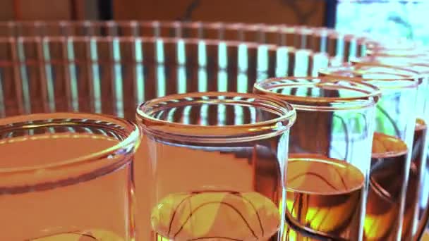 黄色の液体でガラスの瓶を研究室のリング。化学や医療ラボのコンセプトです。4 k シームレス ループ クリップ — ストック動画