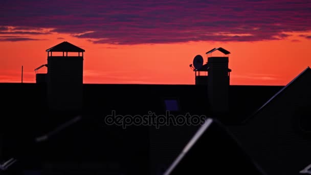 美しいオレンジ色の空と紫の夕焼け雲町傾斜した屋根上に移動します。夜の時間の経過 4 k — ストック動画