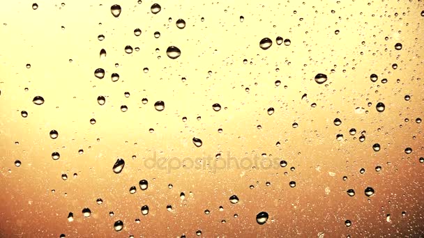 Disparo en cámara lenta de gotas de agua de lluvia de verano en el vidrio de la ventana, colores cálidos de la puesta del sol — Vídeos de Stock