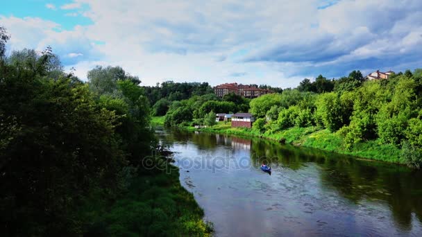 Grabación en cámara lenta de personas no identificadas remando en un bote azul a lo largo del río — Vídeos de Stock