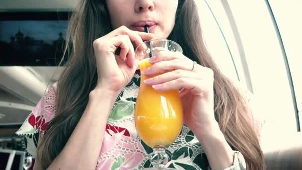 Mulher bonita bebendo suco de laranja com uma palha — Vídeo de Stock