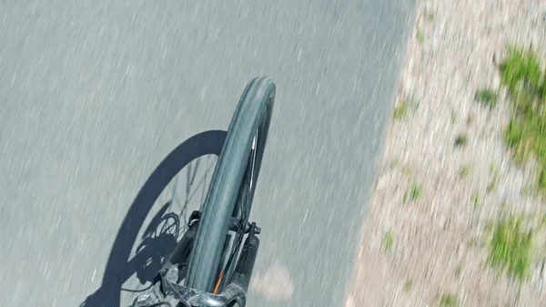 模糊的沥青路面和纺纱自行车前轮和叉子，自上而下的视图 — 图库照片