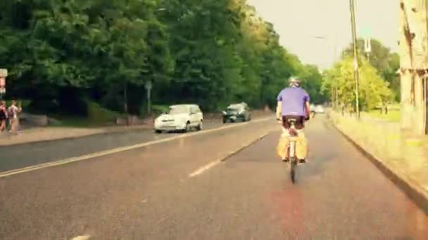 Time lapse of a man riding his bicycle along European city car road — Stock Video