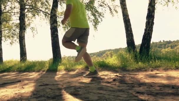 Супер повільний постріл спортсмена, що бігає по парковій алеї — стокове відео